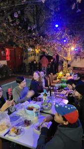 un grupo de personas sentadas en una mesa comiendo comida en Hostel Estacion Mendoza en Mendoza