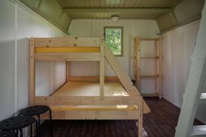 Łóżko piętrowe w niewielkim pokoju z oknem w obiekcie Chatky Skalní mlýn Adršpach w Adršpach
