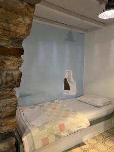 a bedroom with a bed in a room with a stone wall at Cellar Falatados in Mési