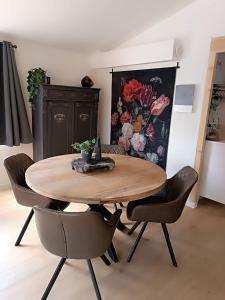 a wooden table and chairs in a room with a kitchen at Time 2 Relax chalet aan het water in Geel