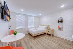 a bedroom with a bed and a table and a tv at Tiger Motel Studio Apartment in Galveston