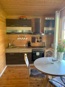 a kitchen with a table and a table and chairs at Pociunai relax house in Pociūnai