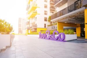 a building with a purple sign that reads yoocoo at YouCo coliving Dubai in Dubai