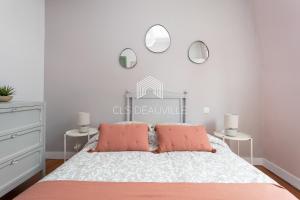 um quarto com uma cama com duas almofadas cor-de-rosa em Maison de Pêcheur La Coquette CLS Deauville em Trouville-sur-Mer