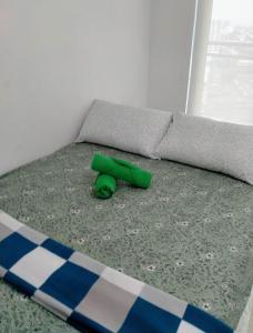 a bed with a green object on the floor at SM Bicutan Affordable Rooms in Manila