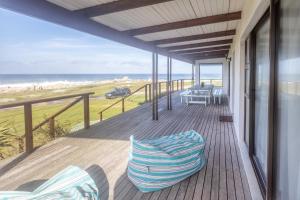 a porch with chairs and a view of the beach at The Beauty of The Wildside in Cape St Francis