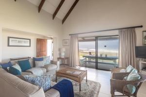 ein Wohnzimmer mit Sofa und Fernseher in der Unterkunft The Beauty of The Wildside 3 bedroom in Cape St Francis
