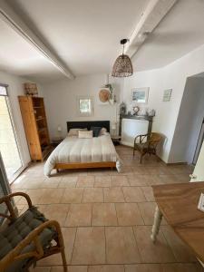 - une chambre avec un lit et une table dans l'établissement Le mazet en été - studio en garrigue nimoise, à Nîmes