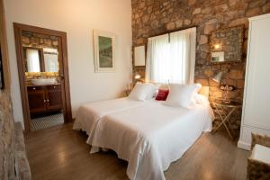 sypialnia z łóżkiem i kamienną ścianą w obiekcie Miraverde Liérganes w mieście Liérganes