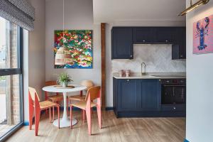 a kitchen with blue cabinets and a table and chairs at The Farm at Avebury in Marlborough