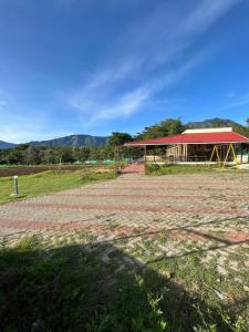 eine Scheune mit rotem Dach und einem Gebäude in der Unterkunft By The River in Masinagudi