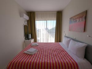 a hotel room with a large bed with a red blanket at IVORY HOTEL in Theologos