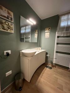 baño con lavabo blanco en una pared verde en A casa di Rachele, en Marina Romea
