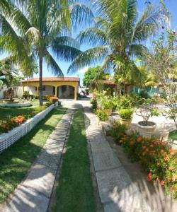 un jardin avec des palmiers et une passerelle dans l'établissement RECANTO DOS LIRAS, à Goiana