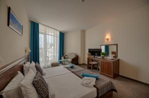 ゴールデン・サンズにあるBerlin Golden Beach Hotel - All Inclusive & Beachのベッドとデスクが備わるホテルルームです。