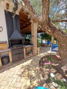 a backyard with an outdoor kitchen with a tree at Casa Rural El Olivar Ronda in Arriate