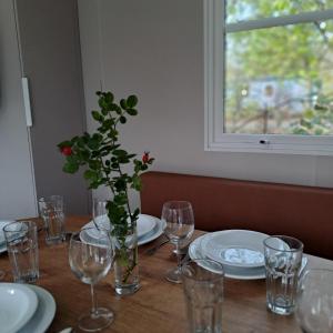 una mesa con gafas y un jarrón con una planta. en Camping Baalse Hei, en Turnhout