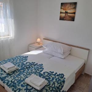 a bedroom with a bed with a blue and white blanket at Apartmani Mila-Casa Bianca in Medulin