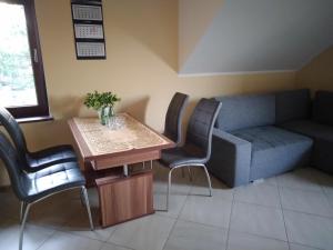 a living room with a couch and a table and chairs at Zaścianek Kaszub in Strzebielino