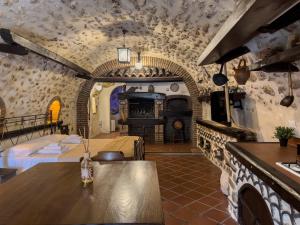 Cette grande chambre dispose d'une table et d'une cheminée. dans l'établissement Santo'S House Luxury - idromassaggio e doccia emozionale, à Santo Stefano di Sessanio