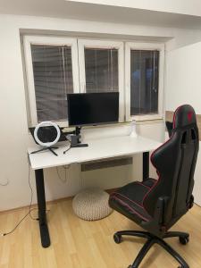 a desk with a computer monitor and a chair at Sunrise Apartment in Skopje