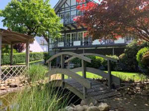 eine Brücke über einen Teich vor einem Haus in der Unterkunft Apartment DaVinci - Sauna, Kamin, Garten, E-Bikes in Olpe