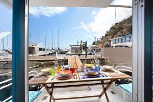 einen Tisch mit Speisen auf einem Balkon mit Blick auf den Yachthafen in der Unterkunft Aloha Jak's Boat in Alassio
