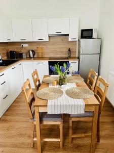 Karlovice的住宿－Rodinný apartmán v Karlovicích，一间带木桌和椅子的厨房和一间带白色橱柜的厨房