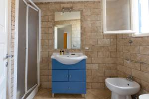 a bathroom with a sink and a toilet and a mirror at Casa Conte Pio in Marettimo