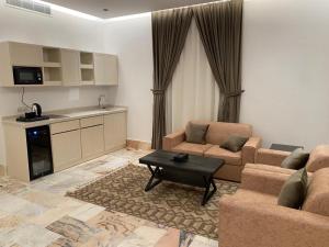 فايف بالم الفندقية في الرياض: غرفة معيشة مع كنبتين وطاولة