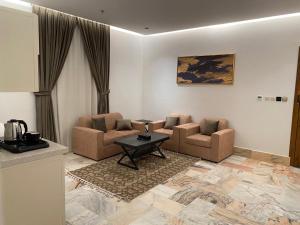 sala de estar con 2 sillas y mesa en فايف بالم الفندقية en Riad