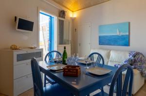 ein Esszimmer mit einem blauen Tisch und Stühlen in der Unterkunft Casa Conte Pio in Marettimo
