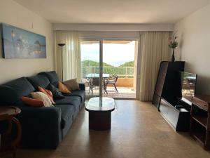 a living room with a couch and a tv and a table at Apartment direkt am Strand in Blanes