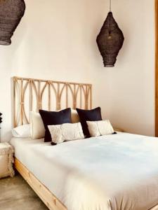 a bed with black and white pillows on it at Casa Doggio, Loft con historia in Cartagena