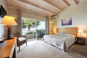 a bedroom with a bed and a large window at Agali Hotel Paxos in Gaios