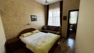 a small bedroom with a bed and a couch at Sultan Pension in Antalya