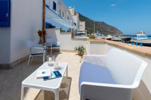 a balcony with a table and chairs and a view of the water at Casa Conte Pio in Marettimo