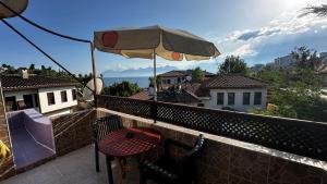 a balcony with a table and an umbrella at Sultan Pension in Antalya