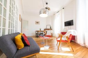 una sala de estar con un sofá y una mesa en La Bohème, appartement chaleureux et décoré avec goût, en Saint-Étienne