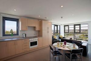 Edinburgh College Residence في إدنبرة: مطبخ وغرفة معيشة مع طاولة وأريكة