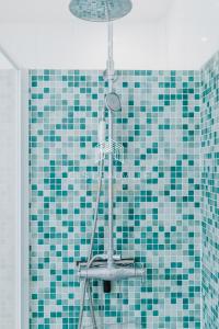 y baño con ducha de azulejos azules y verdes. en Maison de Pêcheur La Coquette CLS Deauville en Trouville-sur-Mer