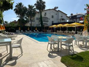 a group of tables and chairs next to a swimming pool at Bellissima Hotel in Side