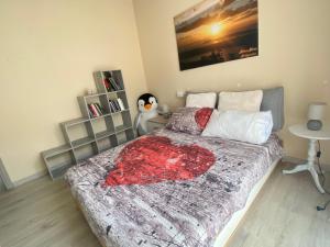 a bedroom with a large bed with a red blanket at la maison du soleil in Colazza