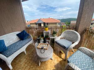 a patio with wicker chairs and a coffee table at la maison du soleil in Colazza