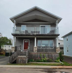 Casa con balcón y puerta roja en Peaceful Water View House! en Charlottetown