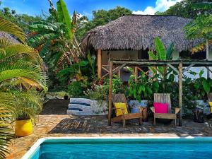 a resort with a pool and chairs and a house at Hotel Cabañas Puesta del Sol in Las Peñitas