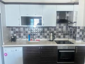 a kitchen with white cabinets and a sink at Eryaman, Wide Luxury Rezidance in Etimesut