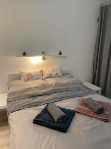 a bed with two pillows and towels on it at Apartment Nitra-city centre in Nitra