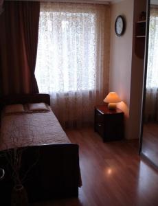a bedroom with a bed and a window with a lamp at Sinay Hotel in Poltava