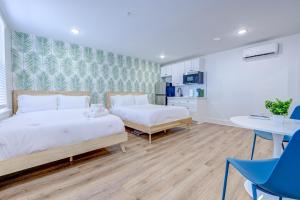 a bedroom with two beds and a table and chairs at Beach House Paradise Studio Apartment 2 Beds in Galveston